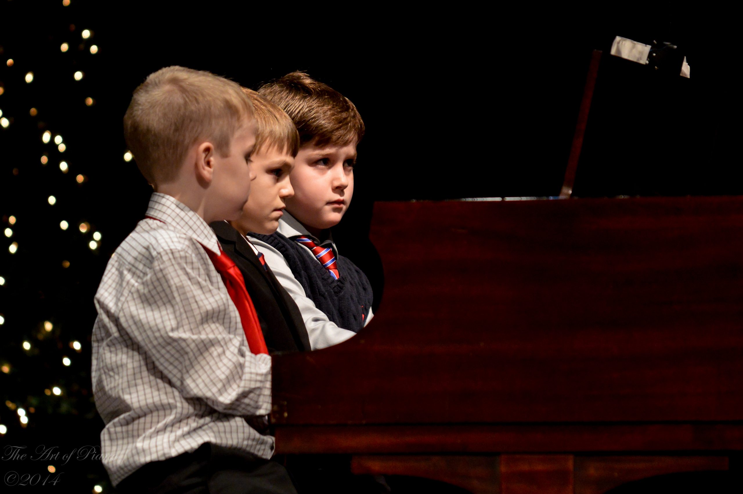 Programs: Three young students perform a piano trio at a recital