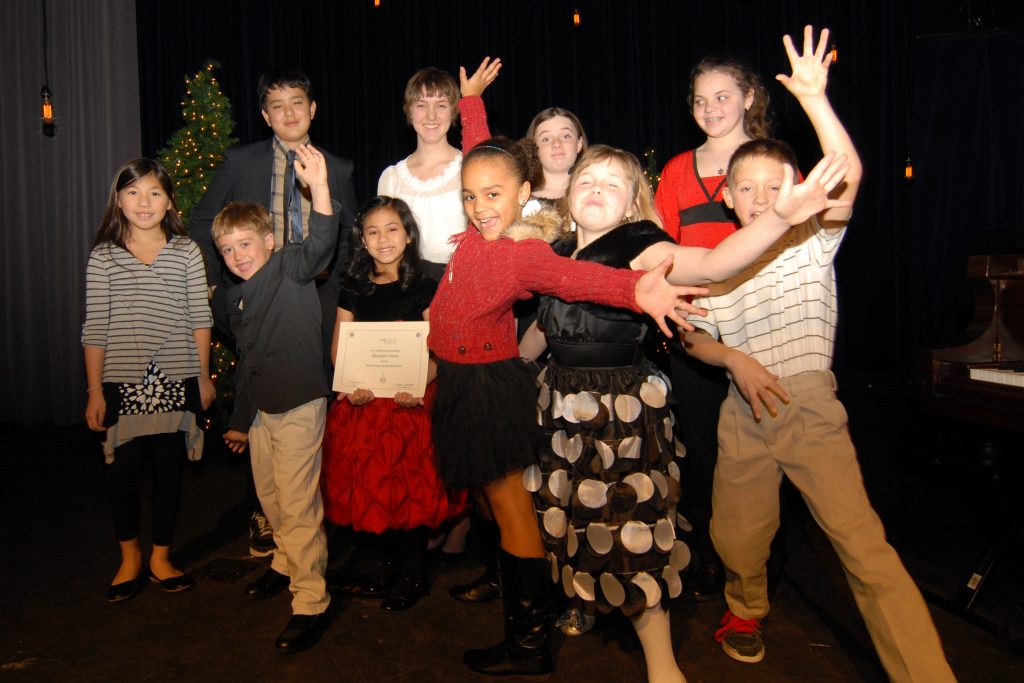 Students strike fun poses after a The Art of Piano recital 
